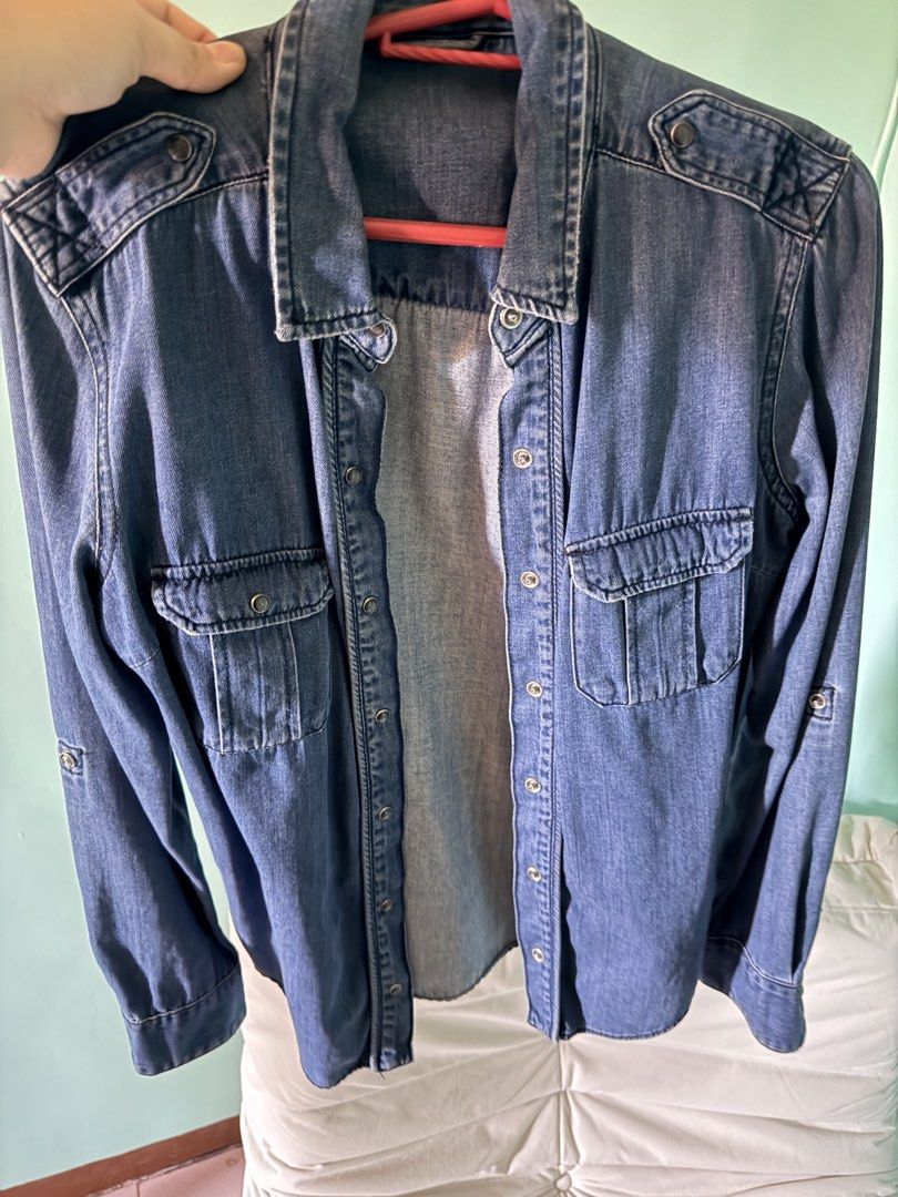 Zara Denim Shirt/ Jacket (Category: Coats, Jackets and Outerwear) located in Cainta. Submitted by Kamilerloo (Listing ID 1429700351, Image 2). Description: Denim jacket or shirt features a classic design with two chest pockets and buttoned cuffs. It has a collared neckline and a button-down front. It has a standard fit and long sleeves. The back of the shirt has a yoke detail. RFS: declutterring .