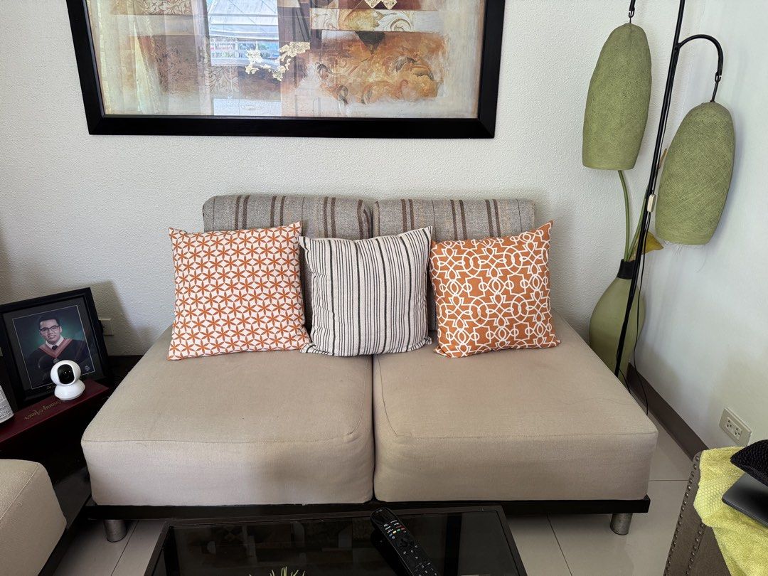 4- Seater Sofa with Pillows (Category: Sofas) located in Rizal. Submitted by christine122592 (Listing ID 1433341651, Image 2). Description: - 4 seater sofa - Neutral beige fabric - Striped backrest design - Dark wooden base with metal legs - Approximately 1.52 meters in length - Perfect for any living room.