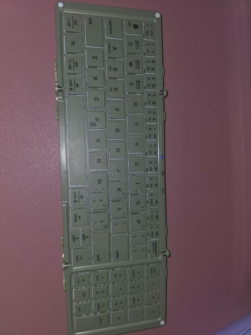 BOW Foldable Wireless Bluetooth Keyboard w/ Numpad (Category: Computer Keyboard) located in Quezon City. Submitted by algeaania (Listing ID 1433385050, Image 1). Description: BOW Foldable Bluetooth Keyboard - Tri-fold design for maximum portability - Compatible with iOS, Android, and Windows - Includes a numeric keypad - Made of lightweight and durable material - Stylish green-grey color - Folds for easy storage Inclusion: - Type C connector - Ke