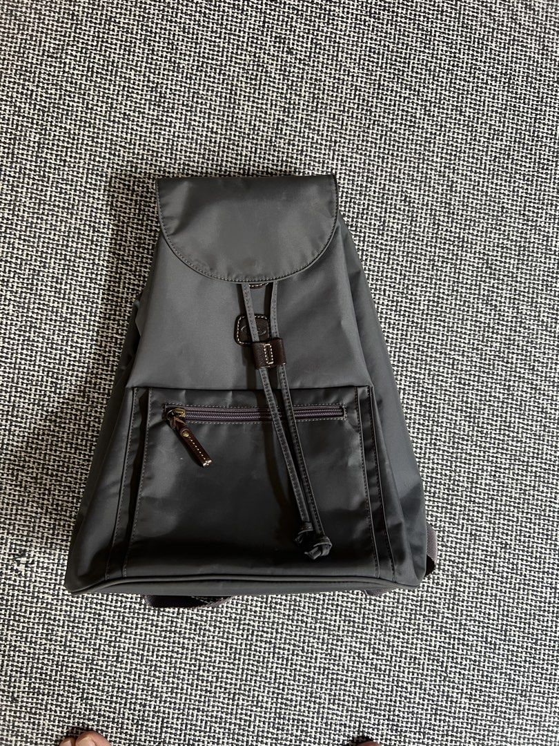 Bric’s Grey Nylon Drawstring Backpack (Category: Backpacks) located in Manila. Submitted by declutteringmomma_ida (Listing ID 1433256010, Image 1). Description: - Grey backpack - Drawstring closure - Front zippered pocket - Adjustable shoulder straps - Top flap - Brown accent details - Smooth, possibly nylon material - Simple and functional design.