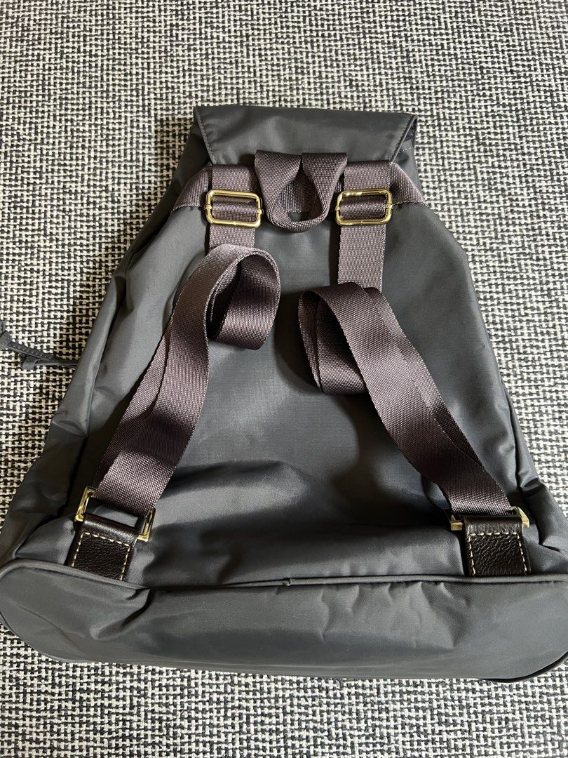 Bric’s Grey Nylon Drawstring Backpack (Category: Backpacks) located in Manila. Submitted by declutteringmomma_ida (Listing ID 1433256010, Image 2). Description: - Grey backpack - Drawstring closure - Front zippered pocket - Adjustable shoulder straps - Top flap - Brown accent details - Smooth, possibly nylon material - Simple and functional design.