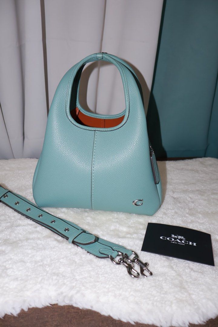 Coach Lana 23 Aquamarine (Category: Luxury Bags & Wallets) located in Paranaque City. Submitted by qwerein (Listing ID 1433216616, Image 1). Description: Coach Lana 23 Aquamarine Rare color/Seasonal 🩵 - Stunning teal color - Matching strap included - Top handle and detachable strap for crossbody wear - Includes Coach tag and care card - Silver-tone Coach logo No issues at all can pass at brandnew! Rfs: decluttering Bought in US! Can show receipt