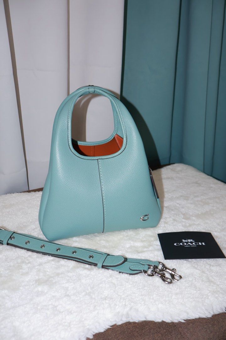 Coach Lana 23 Aquamarine (Category: Luxury Bags & Wallets) located in Paranaque City. Submitted by qwerein (Listing ID 1433216616, Image 2). Description: Coach Lana 23 Aquamarine Rare color/Seasonal 🩵 - Stunning teal color - Matching strap included - Top handle and detachable strap for crossbody wear - Includes Coach tag and care card - Silver-tone Coach logo No issues at all can pass at brandnew! Rfs: decluttering Bought in US! Can show receipt