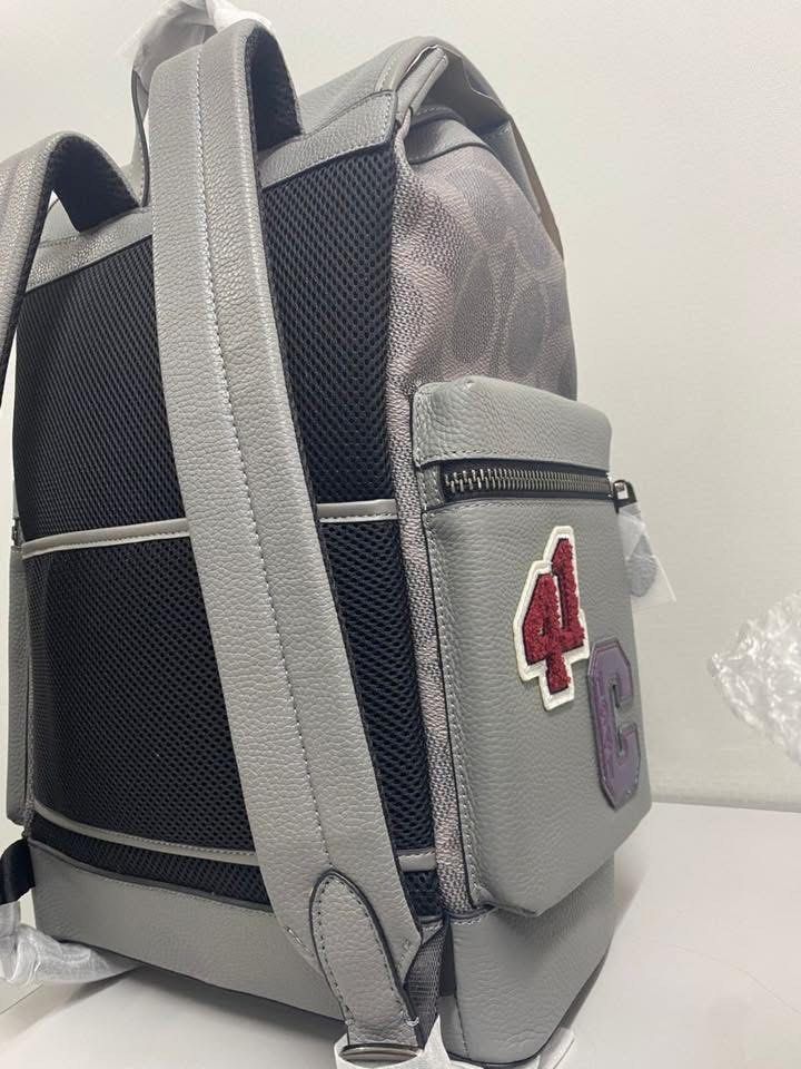Coach Patchwork Backpack (Category: Bags & Wallets) located in Petaling Jaya. Submitted by angah_75 (Listing ID 1433352864, Image 3). Description: - Authentic Coach backpack - Grey leather exterior - Features multiple patches (star, lightning bolt) - Signature Coach pattern - Flap closure - Zippered front pocket - Adjustable shoulder straps - Breathable mesh back panel - Coach logo detail - Small zippered side pocket.