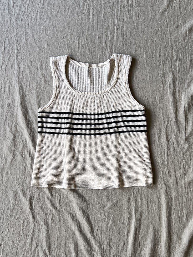 Cream Tank Top with Black Stripes (Category: Sleeveless) located in Quezon City. Submitted by emeles (Listing ID 1433372397, Image 1). Description: - Cream-colored tank top - Textured waffle knit - Three black stripes across chest - Rounded neckline - Sleeveless design - Medium weight fabric - Suitable for warmer weather - Simple and versatile style.