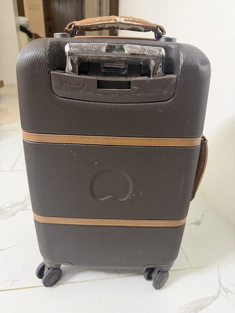 Delsey Suitcase (Category: Luggage) located in Tuguegarao City. Submitted by jeffbmad (Listing ID 1433238160, Image 3). Description: - Delsey suitcase with brown and tan accents - Retractable handle for easy maneuvering - Multiple compartments for organized packing - Includes a TSA lock for added security - Interior features a stylish red lining - Interior includes straps and zippered pockets - Exterior shows wear and tear on handles and corners 