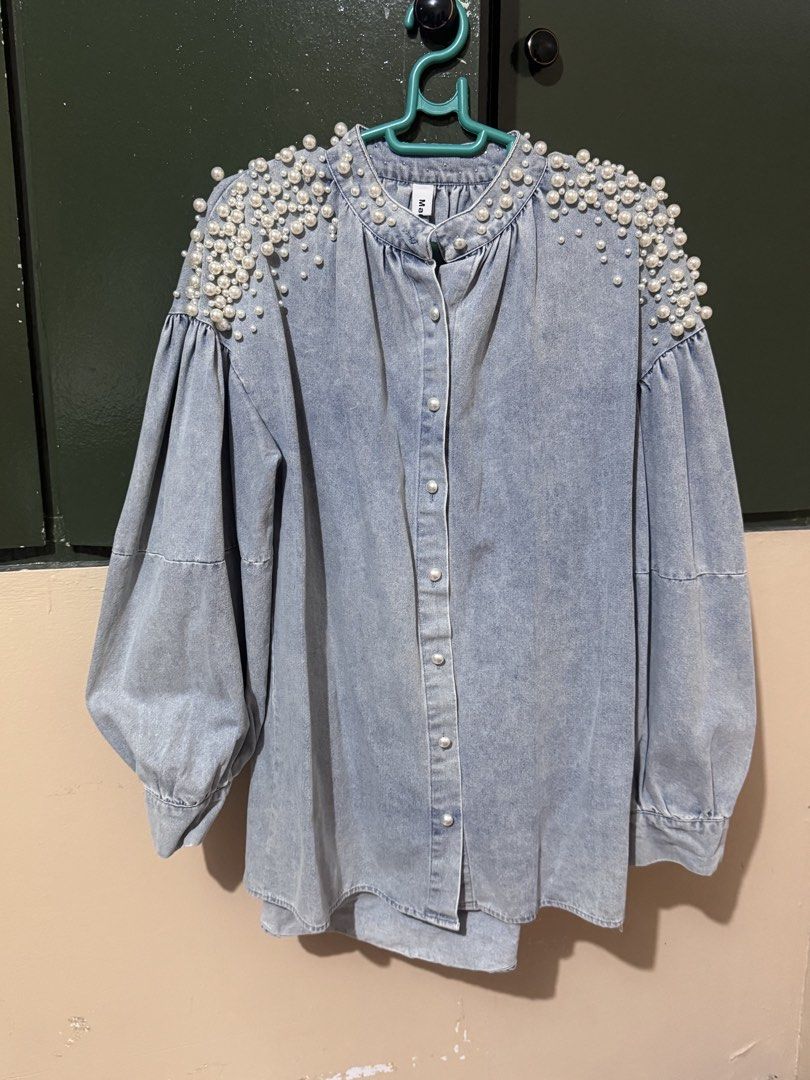 Denim Blouse with Pearl Embellishments (Category: Blouses) located in Quezon City. Submitted by AivFranc (Listing ID 1433215016, Image 1). Description: - Light wash denim blouse - Pearl embellishments on shoulders - Button-down front - Long, puffy sleeves - Round neckline - Adds a touch of elegance.
