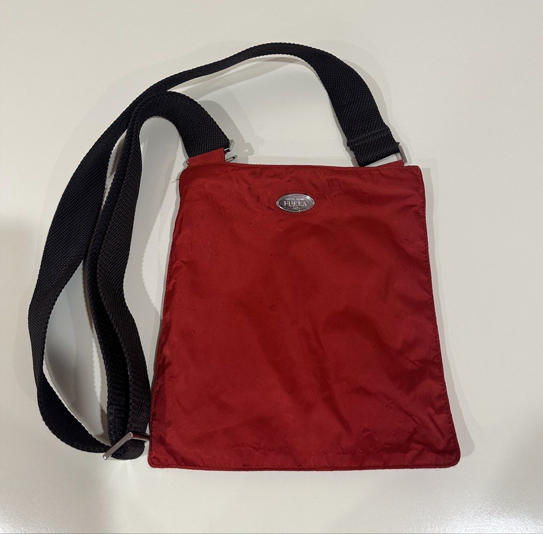 Furla Red Crossbody Bag (Category: Luxury Bags & Wallets) located in Manila. Submitted by caseller26 (Listing ID 1433325090, Image 1). Description: - Furla red crossbody bag - Black adjustable strap - Square shape - Features Furla logo - Made of nylon-like material.