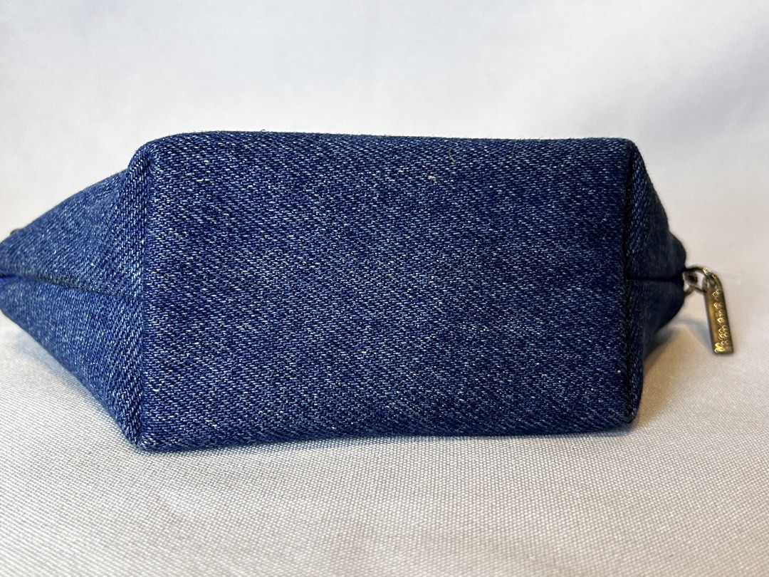 Givenchy Denim Cosmetic Pouch/ WALLET (Category: Luxury Bags & Wallets) located in Manila. Submitted by originalvintagebagph (Listing ID 1433387056, Image 3). Description: Givenchy cosmetic pouch is made of denim and features a studded design. It has a zipper closure and a Givenchy logo charm. The interior is lined with a blue fabric and includes a Givenchy label. The pouch is a unique shape and has a square design made of studs on the front..