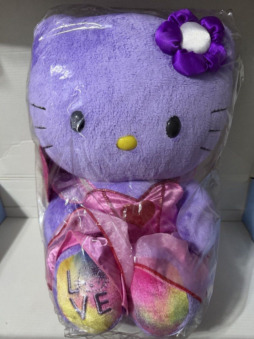 Hello Kitty Bab 2 (Category: Plushies & Soft Toys) located in Makati City. Submitted by prelovedkitty13 (Listing ID 1433322839, Image 1). Description: - Brand new Kitty plush toy - Color: Purple - Features a flower on its head - Wearing a pink dress and shoes - Shoes have the word "LOVE" - Still in original packaging.