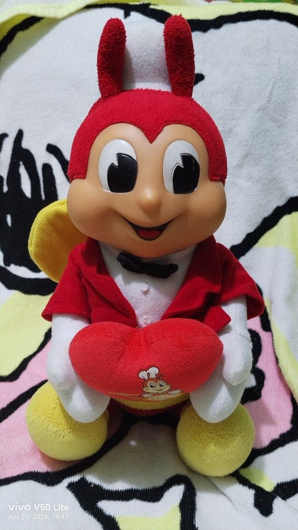 Jollibee 30th Anniversary Plush Toy (Category: Plushies & Soft Toys) located in Mabalacat. Submitted by whowannashoppe (Listing ID 1433318154, Image 1). Description: - Special/limited edition Jollibee plush toy. - Rare collectibles - Celebrates the 30th anniversary. - Features Jollibee holding a heart-shaped pillow. - Classic red and yellow color scheme. - Includes a chef's hat and bow tie. - Approximately 12 inches long. - Made in China. - In ve