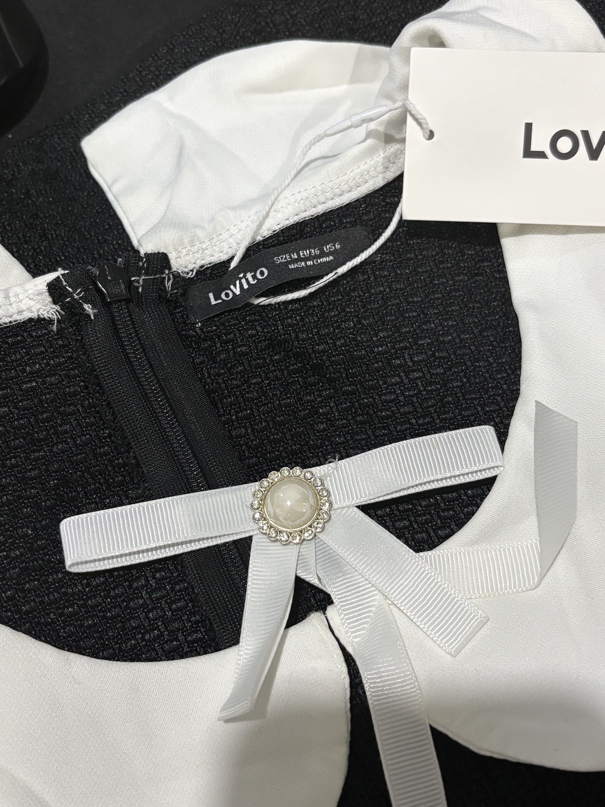 Lovito Black Dress with White Collar (Category: Dresses) located in Quezon City. Submitted by cesscstr (Listing ID 1433239920, Image 2). Description: - Lovito black dress - White Peter Pan collar - Decorative pearl buttons - Bow detail at neckline - Zipper closure - Size: M - Textured fabric.