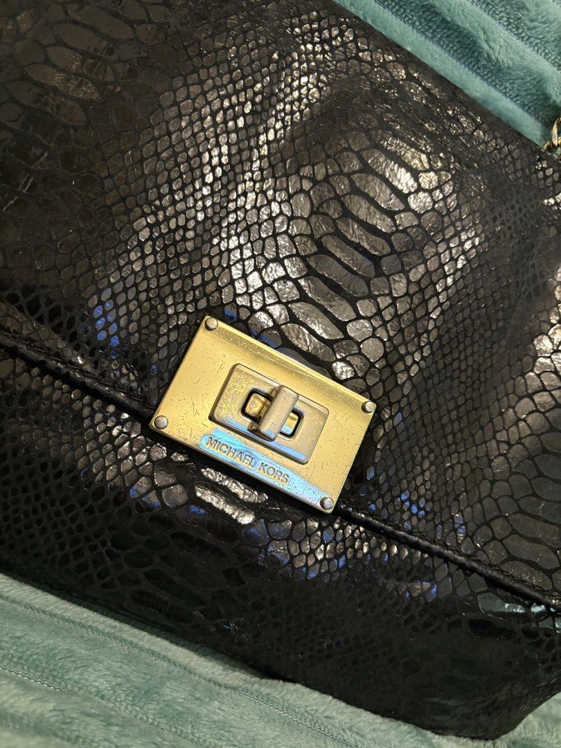 Michael Kors Black Snakeskin Shoulder Bag (Category: Luxury Bags & Wallets) located in Manila. Submitted by budgetpreloveditems (Listing ID 1433383658, Image 2). Description: - Michael Kors shoulder bag - Black snakeskin exterior - Gold chain strap - Gold-tone clasp closure - Interior: Michael Kors logo lining - Interior zippered pocket - Flap closure - Condition: Minor wear on clasp.