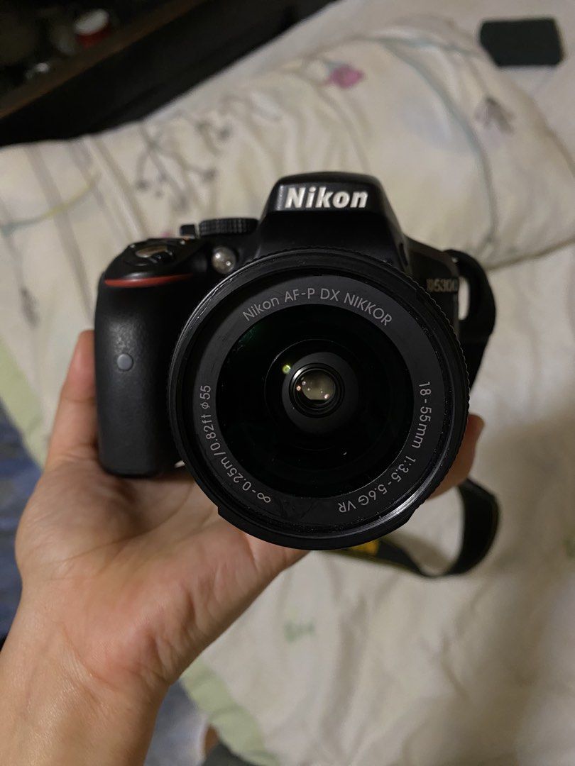 Nikon D5300 DSLR Camera with 18-55mm Lens (Category: Cameras) located in Cebu City. Submitted by soulineeee20 (Listing ID 1433355123, Image 2). Description: - Nikon D5300 DSLR camera - Includes 18-55mm lens (Nikon AF-P DX NIKKOR 18-55mm f/3.5-5.6G VR) - Black camera body - Features a flip-out screen - Comes with camera bag, charger, and cables.