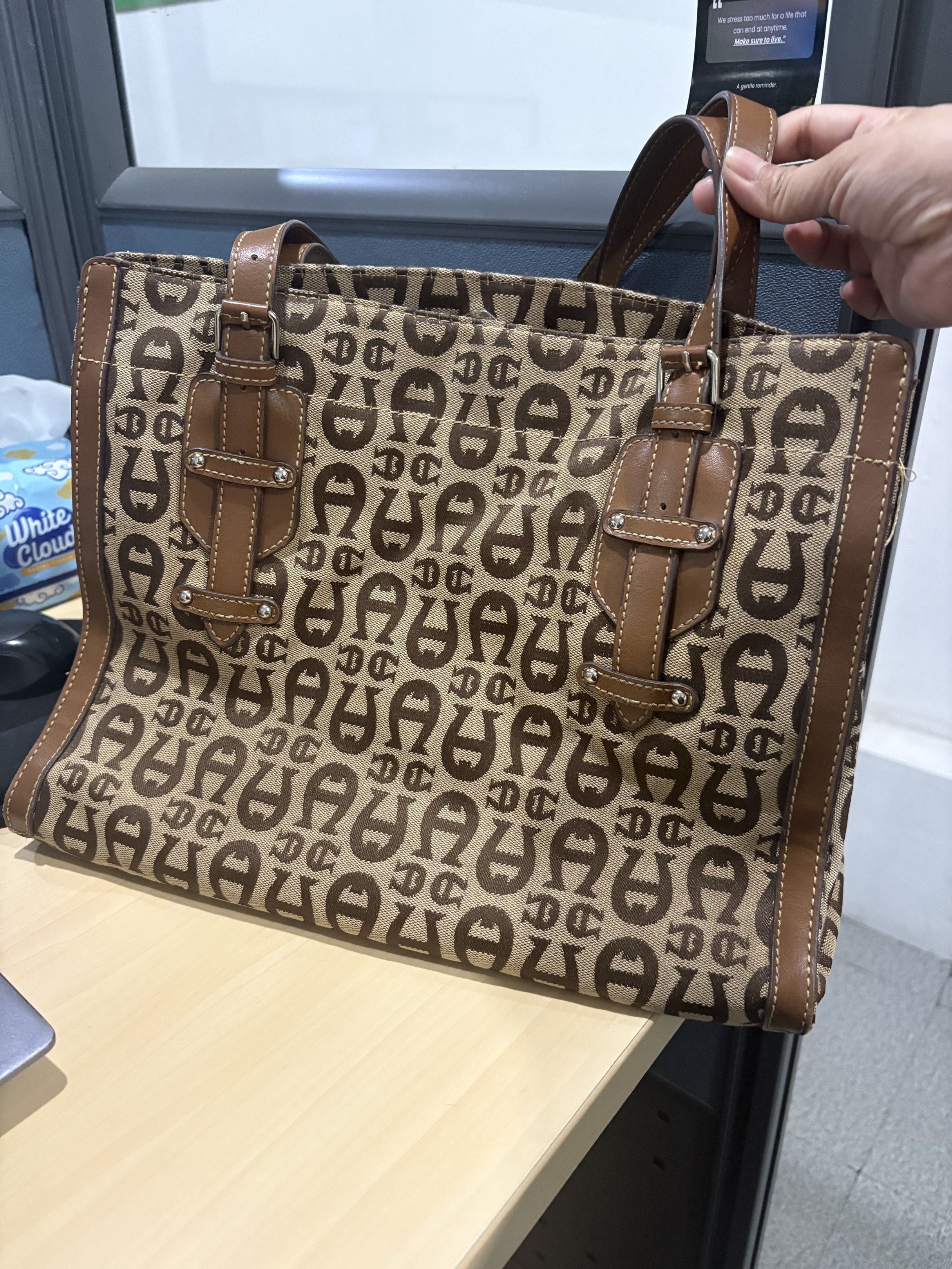 Orignal vintage Aigner Tote Bag (Category: Luxury Bags & Wallets) located in Quezon City. Submitted by cesscstr (Listing ID 1433236643, Image 1). Description: - Aigner tote bag with monogram pattern. - Color: Brown and beige. - Brown leather handles and trim. - Rectangular shape with a spacious interior. - Classic design and structured silhouette. - Double handle for carrying..
