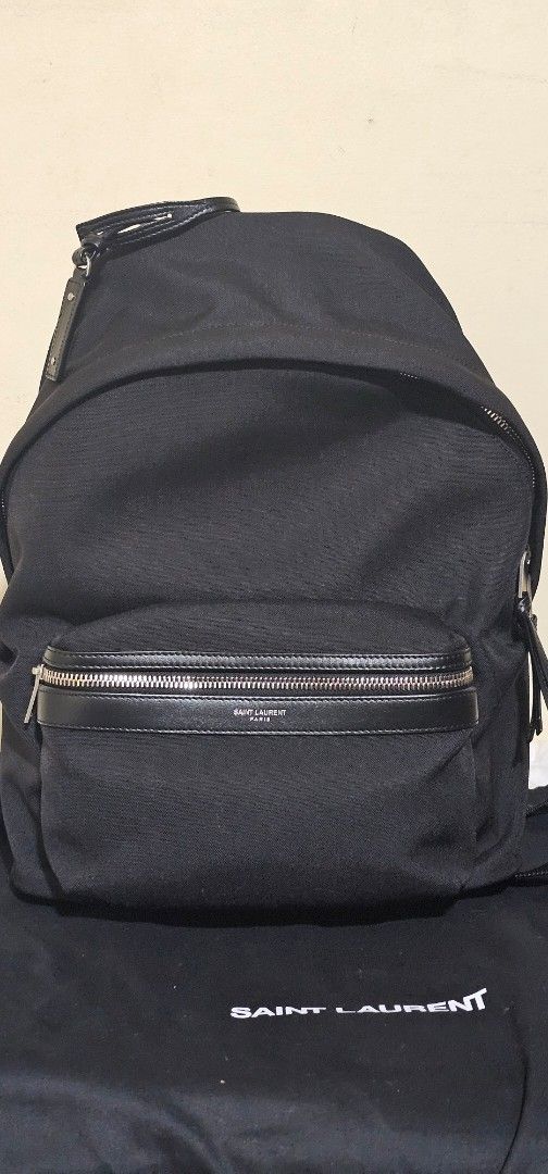 Saint Laurent City Backpack (Category: Luxury Bags & Wallets) located in Cebu City. Submitted by dg_enterprise (Listing ID 1433346514, Image 1). Description: - Authentic Saint Laurent City backpack - Color: Black Canvas - Features a front zip pocket with leather trim and silver-tone zipper - Includes dust bag and authenticity cards - Interior features a Saint Laurent leather patch - Adjustable straps and top handle - Saint Laurent logo visible on