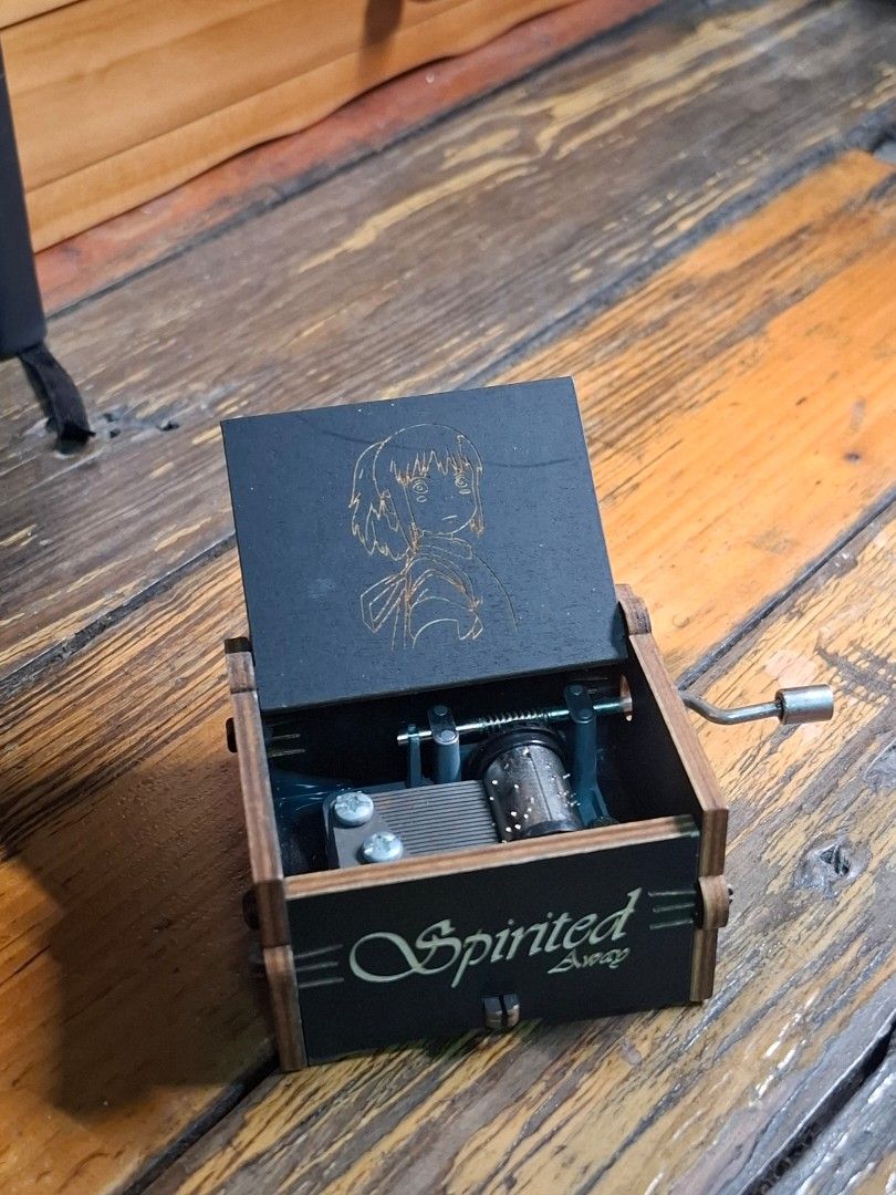 Spirited Away Music Box (Category: Vintage Collectibles) located in Manila. Submitted by riri_laine (Listing ID 1433274285, Image 1). Description: - Spirited Away themed music box - Features intricate laser-cut details - Includes characters and Japanese text - Plays a musical tune - Black box with wooden accents - "Spirited Away" text on the side.