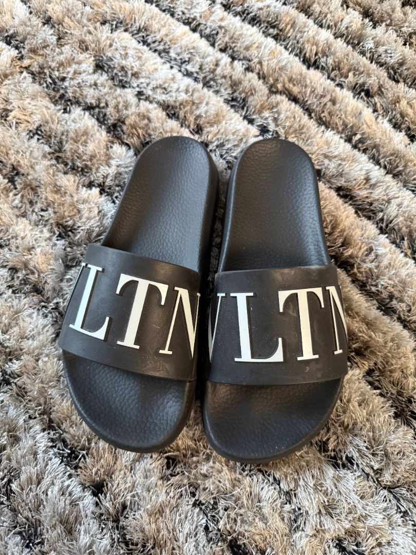 Valentino VLTN Slides (Category: Sneakers & Footwear) located in Muntinlupa City. Submitted by clauisstuff (Listing ID 1433232783, Image 1). Description: 100% AUTHENTIC VLTN Rubber Slides Rarely used Current Retail Price: PHP PHP 27,000 - Size 40, but runs small - VLTN logo in white RFS: Decluttering MOP: BDO/BPI/GotTyme only LOC: Taguig/Muntinlupa.