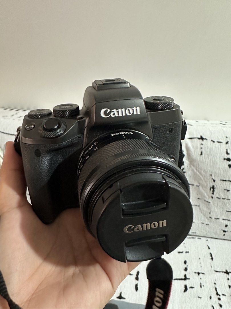 Canon EOS M5 Camera with Lens (Category: Cameras) located in Las Pinas. Submitted by truecrystal-76d40f (Listing ID 1433429750, Image 2). Description: - Canon EOS M5 camera body (black) - Includes 15-45mm lens - Comes with Canon battery and charger - Includes neck strap - Features a flip-out screen - Lens has image stabilization - Easy access to settings via dials and buttons.