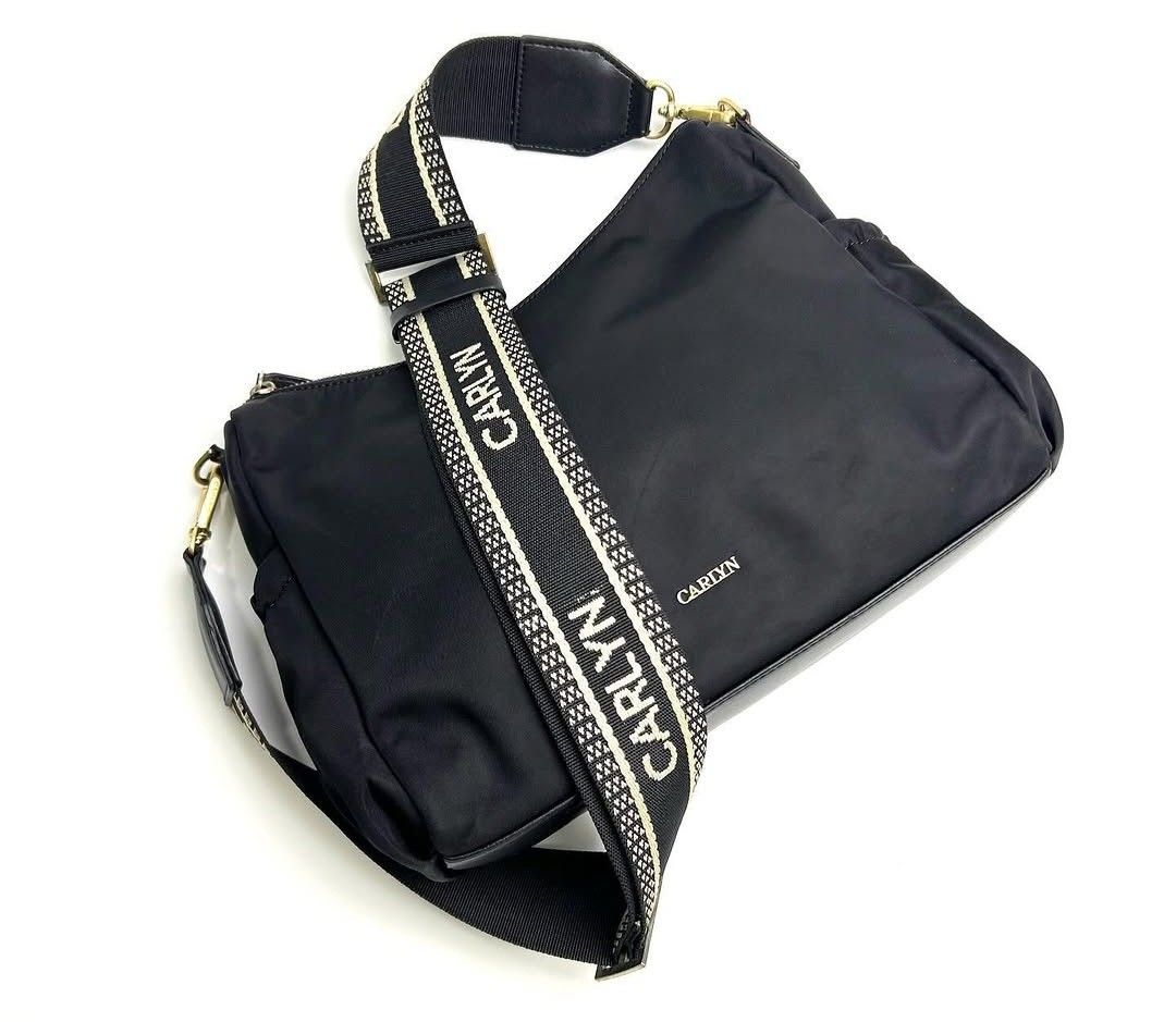 Carlyn Black Shoulder Bag (Category: Shoulder Bags) located in Baguio. Submitted by msgold2601 (Listing ID 1433576324, Image 2). Description: - Black Carlyn shoulder bag - Wide strap with brand name - Zippered main compartment - Additional side pocket - Detachable strap included - Gold-toned hardware - Black interior with Carlyn branding - Made of a nylon-like material.