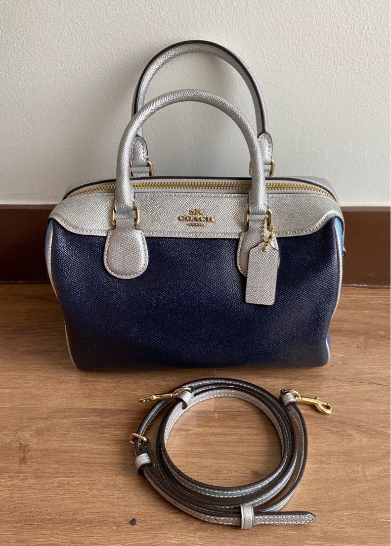 Coach Mini Boston Bag Navy Silver (Category: Luxury Bags & Wallets) located in Pasay City. Submitted by favepieces888 (Listing ID 1433460571, Image 1). Description: - Coach Mini Boston Bag - Color: Metallic Navy, Skyblue & Silver - Top zip closure - Dual top handles - Adjustable, detachable shoulder strap - Includes Coach hang tag - Fabric lining - Coach leather tag Flaw: mild peeling leather on tag inside bag No issues on the overall bag and str
