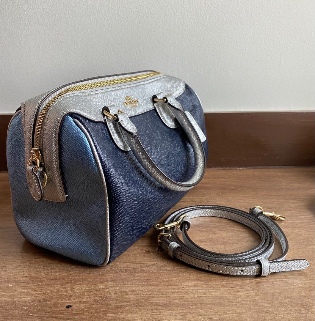 Coach Mini Boston Bag Navy Silver (Category: Luxury Bags & Wallets) located in Pasay City. Submitted by favepieces888 (Listing ID 1433460571, Image 3). Description: - Coach Mini Boston Bag - Color: Metallic Navy, Skyblue & Silver - Top zip closure - Dual top handles - Adjustable, detachable shoulder strap - Includes Coach hang tag - Fabric lining - Coach leather tag Flaw: mild peeling leather on tag inside bag No issues on the overall bag and str