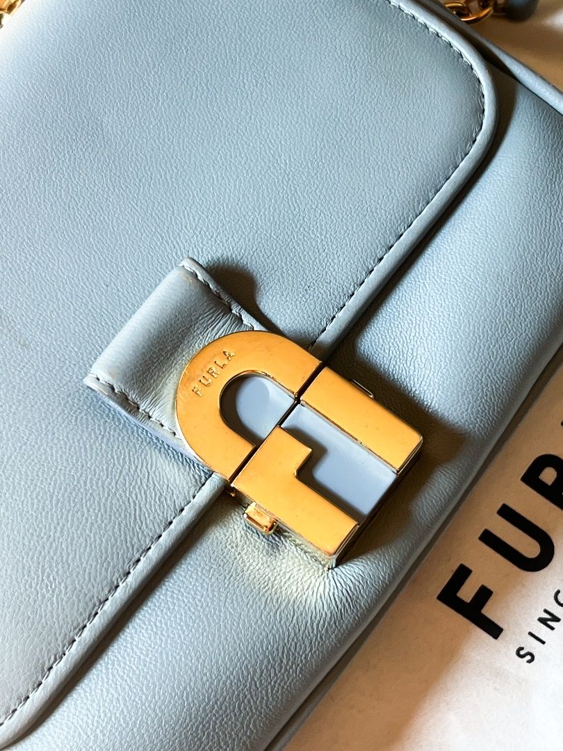 Furla Mini Crossbody Bag (Category: Luxury Bags & Wallets) located in Caloocan City. Submitted by peppery14 (Listing ID 1433467996, Image 2). Description: - Pre-loved - Authentic Furla Metropolis Mini crossbody bag - Light blue color - Gold-tone chain strap - Signature Furla lock closure - Includes dust bag and tag - Multiple interior compartments - Made in Italy.