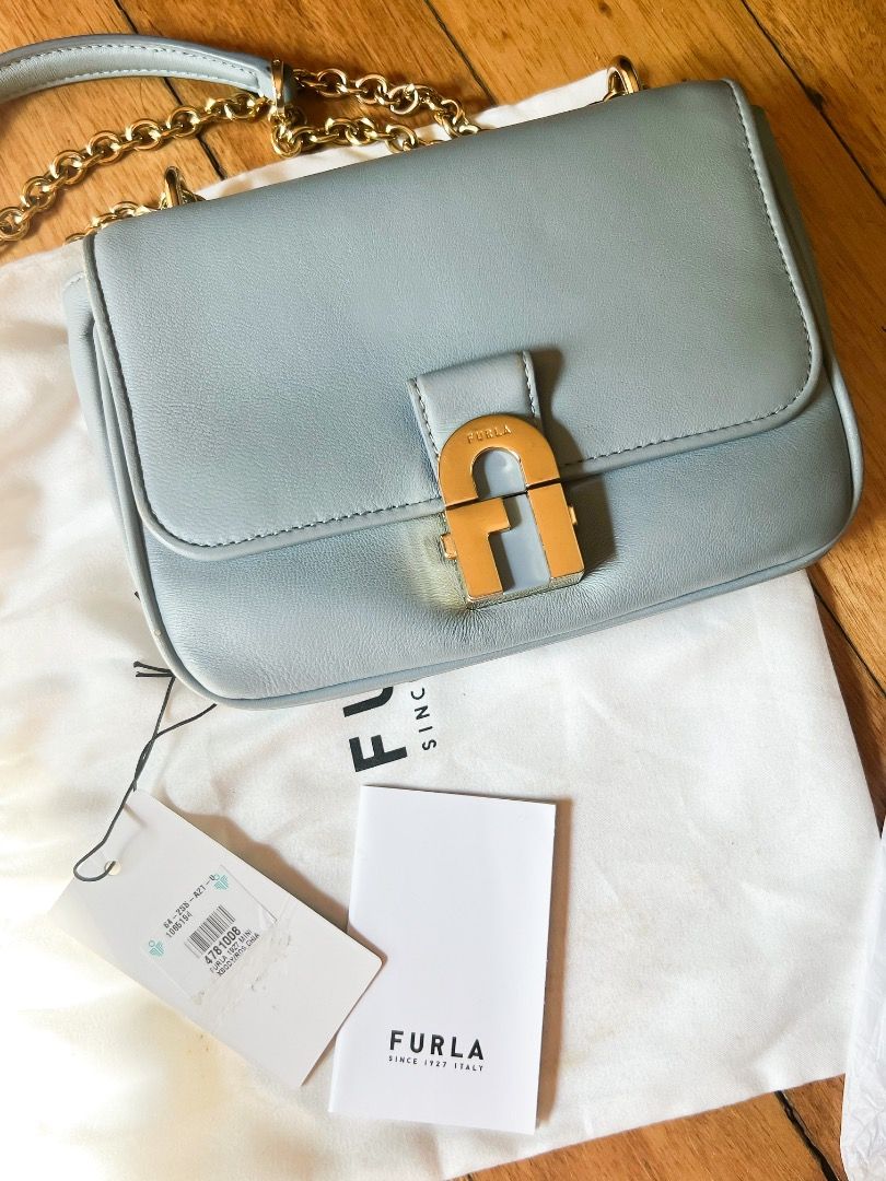 Furla Mini Crossbody Bag (Category: Luxury Bags & Wallets) located in Caloocan City. Submitted by peppery14 (Listing ID 1433467996, Image 1). Description: - Pre-loved - Authentic Furla Metropolis Mini crossbody bag - Light blue color - Gold-tone chain strap - Signature Furla lock closure - Includes dust bag and tag - Multiple interior compartments - Made in Italy.