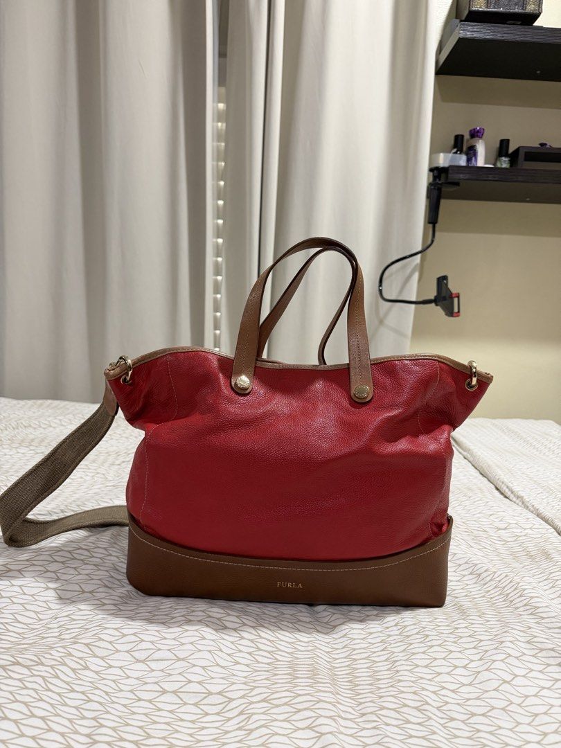 Furla Red and Brown Leather Tote Bag (Category: Luxury Bags & Wallets) located in Mandaluyong City. Submitted by kqloset (Listing ID 1433456512, Image 2). Description: Measurements: Width: 36-45cm Height : 30cm Depth: 13cm Shoulder drop: 50cm - Authentic Furla tote bag - Eye-catching red leather exterior with brown base and handles - Includes a detachable shoulder strap for multiple carrying options - Interior features patterned lining with a zip