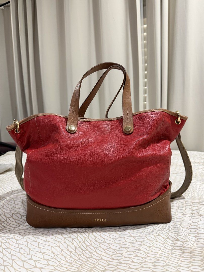 Furla Red and Brown Leather Tote Bag (Category: Luxury Bags & Wallets) located in Mandaluyong City. Submitted by kqloset (Listing ID 1433456512, Image 1). Description: Measurements: Width: 36-45cm Height : 30cm Depth: 13cm Shoulder drop: 50cm - Authentic Furla tote bag - Eye-catching red leather exterior with brown base and handles - Includes a detachable shoulder strap for multiple carrying options - Interior features patterned lining with a zip