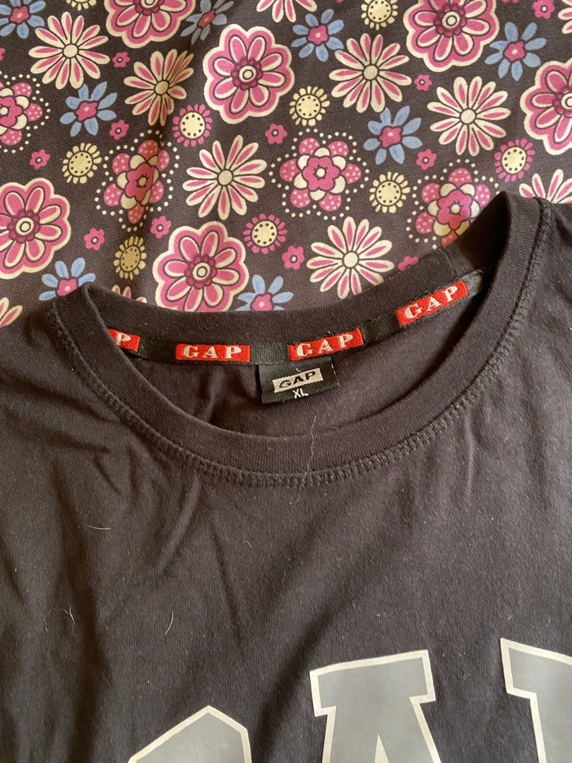 GAP Black T-shirt with American Flag (Category: Tshirts & Polo Shirts ) located in Manila. Submitted by kathhhhh236 (Listing ID 1433546913, Image 3). Description: - Black GAP t-shirt - Features a large "GAP" logo and American flag graphic - GAP logo on sleeve and neckline - Size: XL - Material: 100% cotton - Made in Bangladesh.
