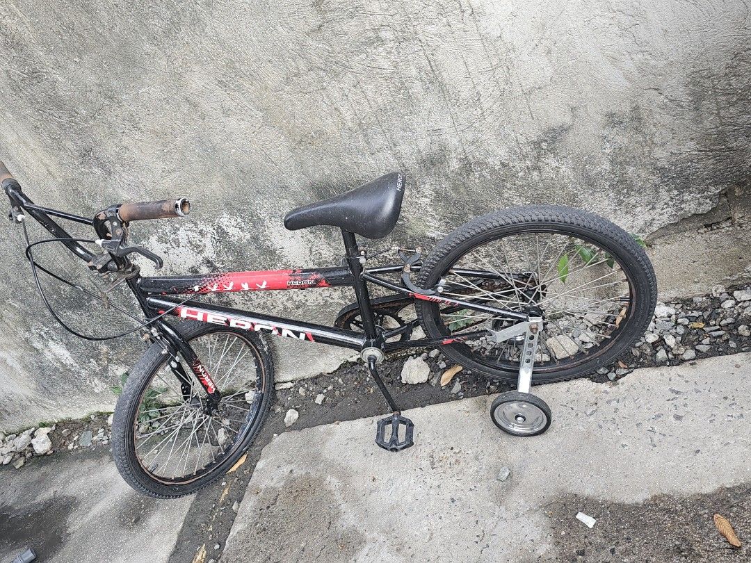 Heron BMX Bike with Training Wheels (Category: Bicycles) located in Paranaque City. Submitted by charlottearrio_23 (Listing ID 1433581271, Image 2). Description: - Heron BMX bike - Color: Black and red - Features black seat, handlebars, and pedals - Includes training wheels - Sturdy frame - Good tire tread - Suitable for beginner riders - Ready to use with signs of usage as you can see in the pic may Rust na ang bike..