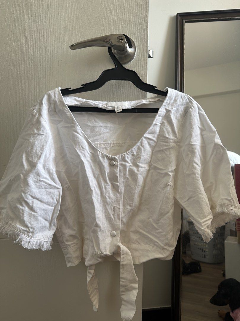 H&M White Cropped Blouse (Category: Blouses) located in Paranaque City. Submitted by declutterwyae (Listing ID 1433464144, Image 1). Description: - H&M white cropped blouse - Size: S - Features: - Scoop neckline - Button-down front - Tie detail at waist - Short sleeves with fringe.