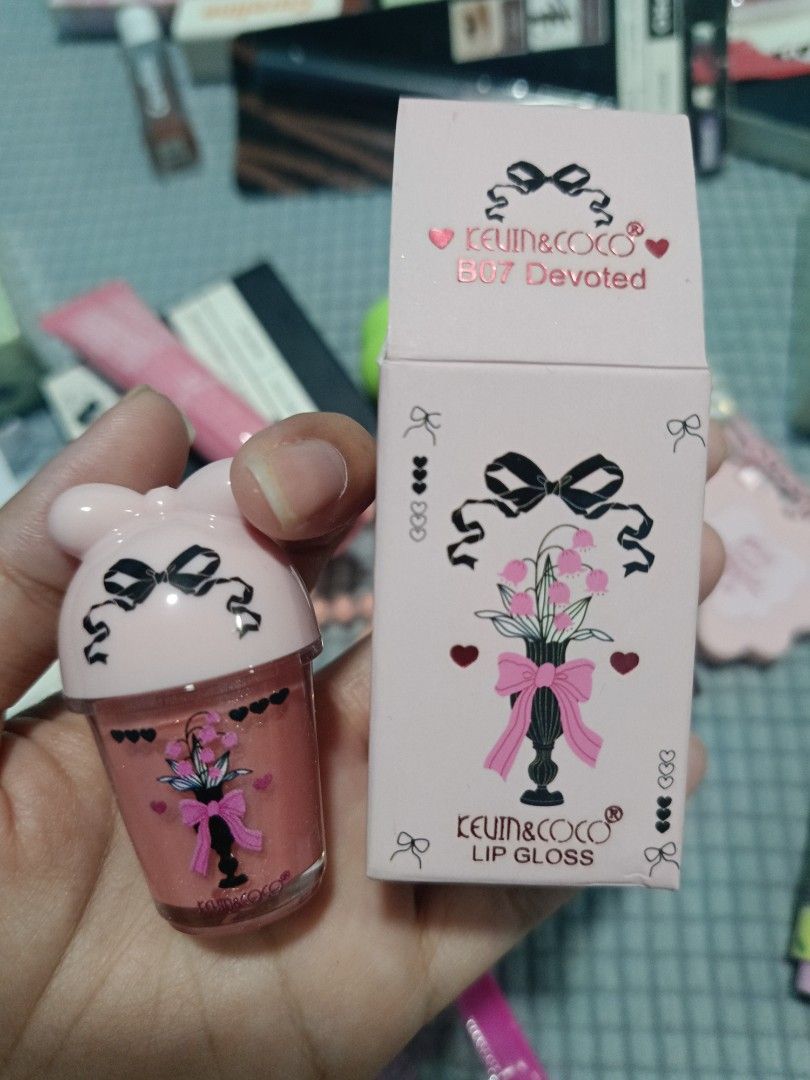 KEVIN & COCO Lip Gloss High Pigmentation Easy to Blend Shade B07 Devoted (Category: Makeup) located in Los Banos. Submitted by donnaalbay47990 (Listing ID 1433578361, Image 1). Description: KEVIN & COCO lip gloss in shade B07 Devoted. The lip gloss has a cute, pink, ice cream cup-shaped container with a bow design. The packaging includes a matching pink box with the brand name and product details..