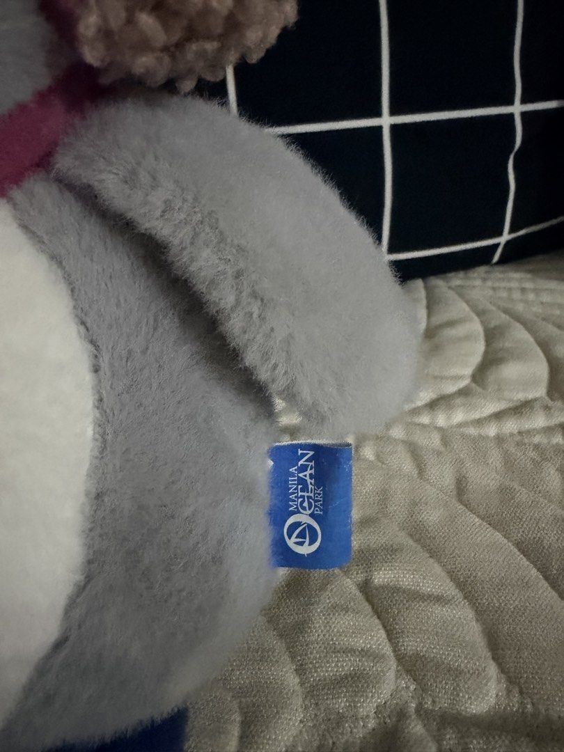 Manila Ocean Park Penguin Plush Toy (Category: Plushies & Soft Toys) located in Quezon City. Submitted by chariesannerivera (Listing ID 1433444705, Image 2). Description: - Adorable penguin plush toy - Sourced from Manila Ocean Park - Features a gray and white body - Includes a pink scarf and earmuffs - Blue nose and feet - Adorned with a flower-shaped button - Manila Ocean Park tag is attached.
