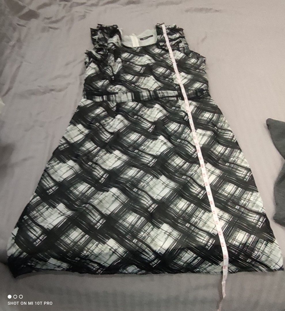 MNG Black and White Dress (Category: Dresses) located in Cavite. Submitted by Combiishop (Listing ID 1433454980, Image 3). Description: - Sleeveless dress - Black and white plaid pattern - Ruffled neckline - Fitted waist - Flared skirt - Zipper closure - Approximately 35 inches in length - Brand tag visible.