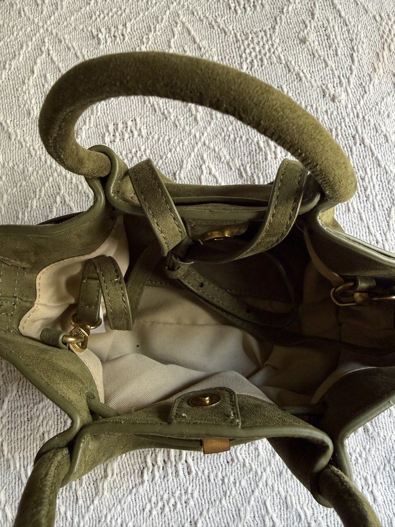 Olive Green Suede Handbag with Top Handle (Category: Tote Bags) located in Paranaque City. Submitted by izdeclutters (Listing ID 1433423001, Image 2). Description: - Olive green suede handbag - Top handle and detachable shoulder strap - Gold-tone clasp closure - Structured design - Light-colored interior lining - Includes a small interior pocket Purchased in Vietnam .