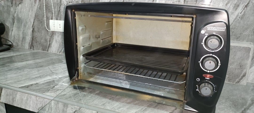 Oven (Category: Ovens & Toasters) located in Makati City. Submitted by tabsilog (Listing ID 1433540239, Image 3). Description: - Tough Mama oven toaster - Multiple control knobs - Includes wire rack and baking tray - Glass door for easy viewing - Black exterior - In good working condition.