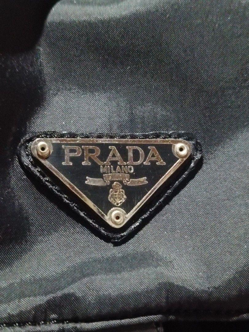 Prada Black Nylon Backpack (Category: Luxury Bags & Wallets) located in Rizal. Submitted by judithtillo19 (Listing ID 1433551940, Image 2). Description: - Prada backpack - Classic black nylon - Prada logo detail - Two front pockets with buckle closures - Adjustable straps for comfort - Top handle for easy carrying - Secure drawstring closure - Made from durable nylon Note: sign of usage, please refer last to pics....ipapasok and need lng lng higp