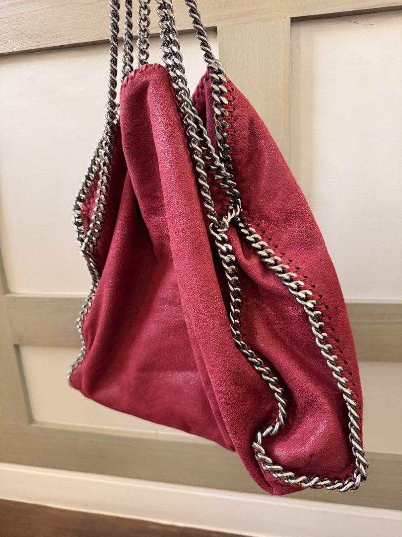 Stella McCartney Falabella Tote Bag (Category: Luxury Bags & Wallets) located in Santa Rosa. Submitted by privateclosetsale (Listing ID 1433435081, Image 2). Description: Stylish Stella McCartney Falabella tote bag in a vibrant red hue. Features a signature chain strap and trim. Includes a dust bag for storage. The bag is shown being worn, demonstrating its size and style..