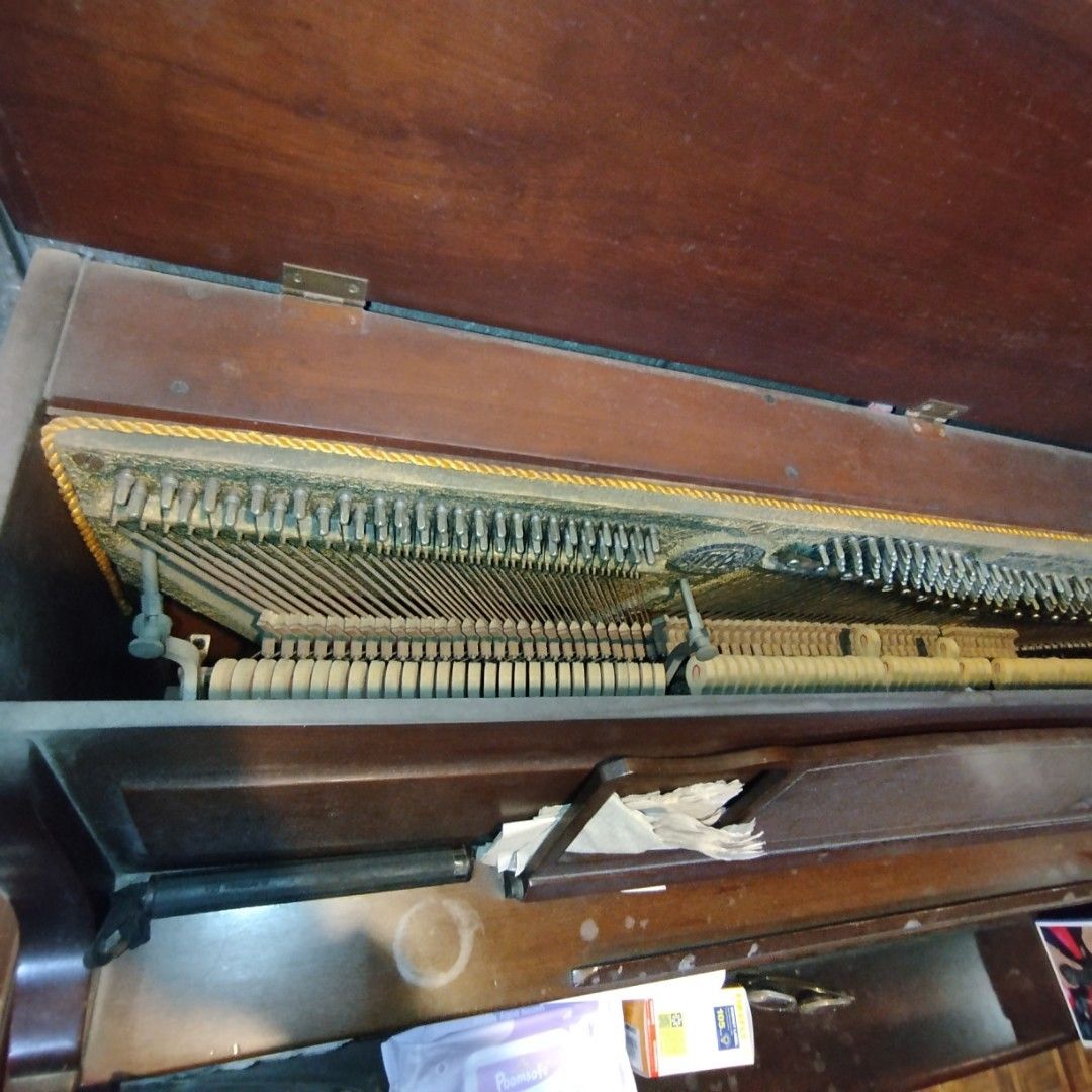 Trebel Upright Piano - Made in Germany (Category: Musical Instruments) located in Manila. Submitted by jojomengui26850 (Listing ID 1433447263, Image 2). Description: - Vintage Trebel upright piano - Dark wooden cabinet - Made in Germany - Visible internal mechanism (strings and hammers) - Features Trebel brand name plate - Includes patent registration.