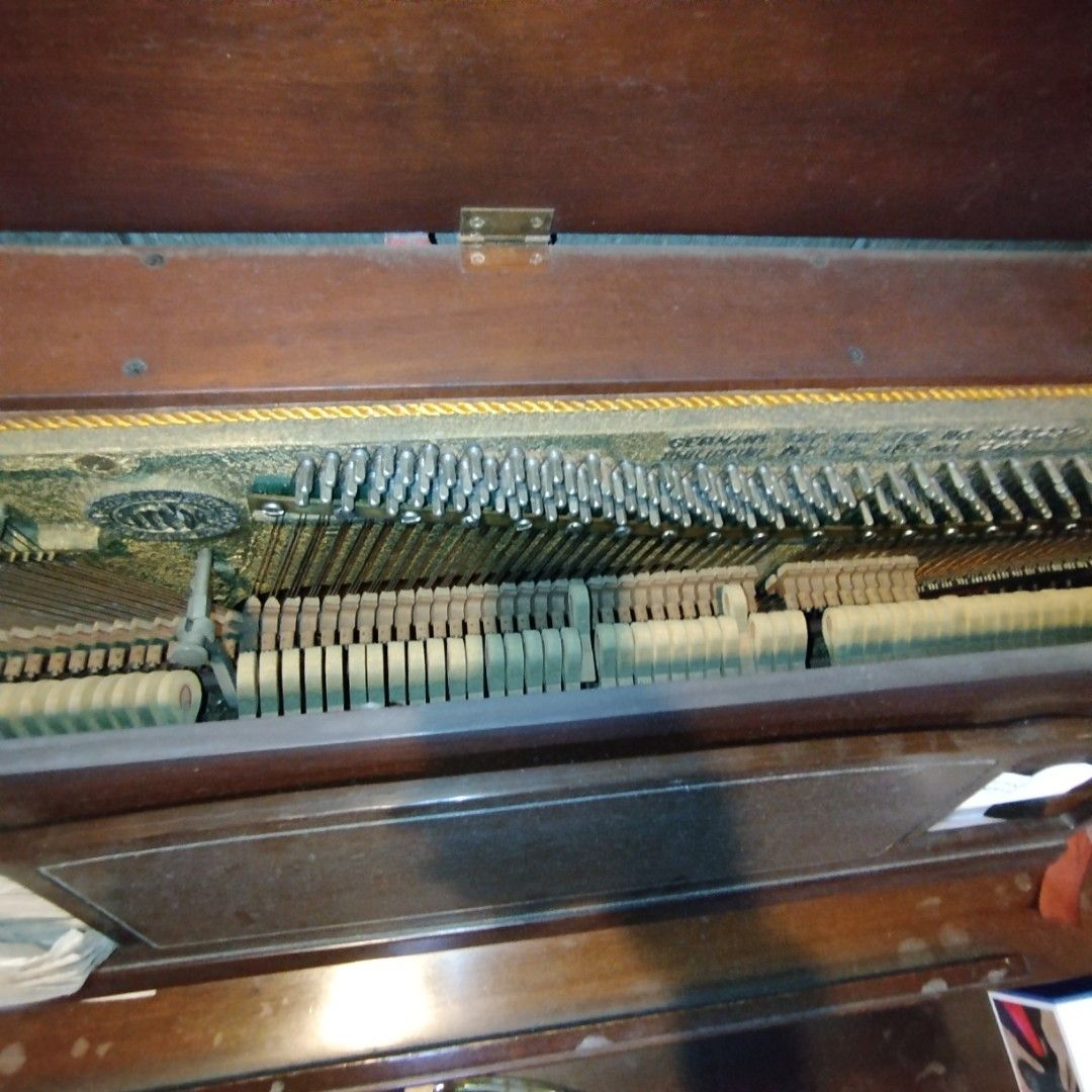 Trebel Upright Piano - Made in Germany (Category: Musical Instruments) located in Manila. Submitted by jojomengui26850 (Listing ID 1433447263, Image 3). Description: - Vintage Trebel upright piano - Dark wooden cabinet - Made in Germany - Visible internal mechanism (strings and hammers) - Features Trebel brand name plate - Includes patent registration.