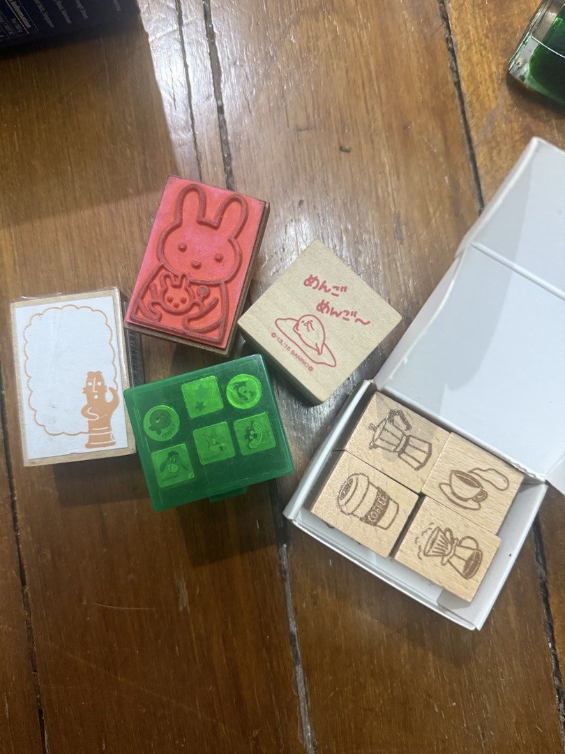 Assorted Stamp Set (Category: Craft Supplies & Tools) located in Marikina City. Submitted by ellapam (Listing ID 1433664016, Image 1). Description: - Adorable stamp set with diverse designs. - Features stamps with bunnies, characters, coffee themes, and other cute illustrations. - Includes a green case for storage. - Some stamps are in a white box. - Ideal for crafting and adding a unique touch to your projects..