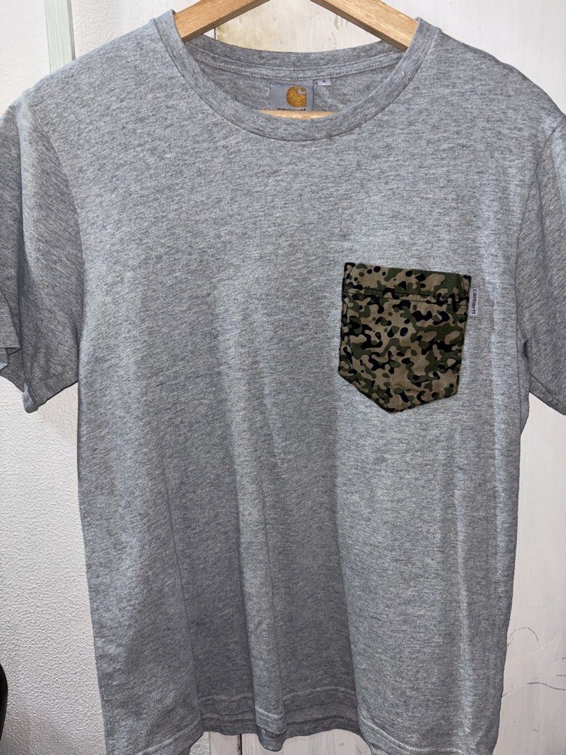 Carhartt Camo Pocket Tee (Category: Tshirts & Polo Shirts ) located in Quezon City. Submitted by bigbert99 (Listing ID 1433727871, Image 1). Description: - Gray Carhartt t-shirt - Camouflage pocket - Crew neck - Short sleeves - Carhartt logo on pocket and neckline - Comfortable, soft material.