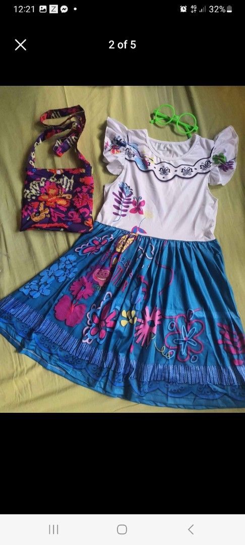 Encanto Dress with Accessories (Mirabel) (Category: Babies & Kids Fashion) located in Pasig City. Submitted by peppermintpatty_1221 (Listing ID 1433778241, Image 1). Description: - Encanto-themed dress - White top with floral accents - Blue skirt with vibrant floral patterns - Includes matching handbag - Comes with green glasses - Perfect for dress-up or themed parties.