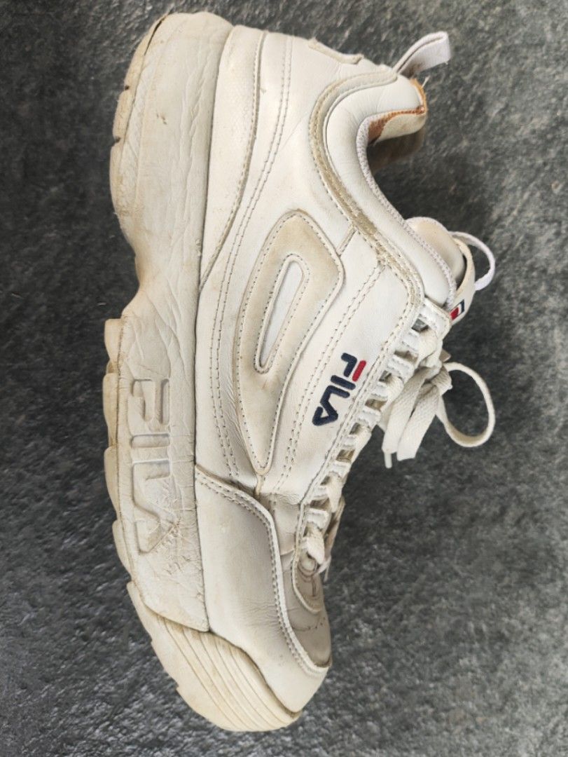 Fila Disruptor II White Sneakers (Category: Sneakers) located in Tagudin. Submitted by 77sleep (Listing ID 1433661299, Image 2). Description: - Fila Disruptor II sneakers - White color - Fila logo on tongue and side - Chunky sole - White laces - Pre-owned condition - Visible wear and tear on soles and uppers.