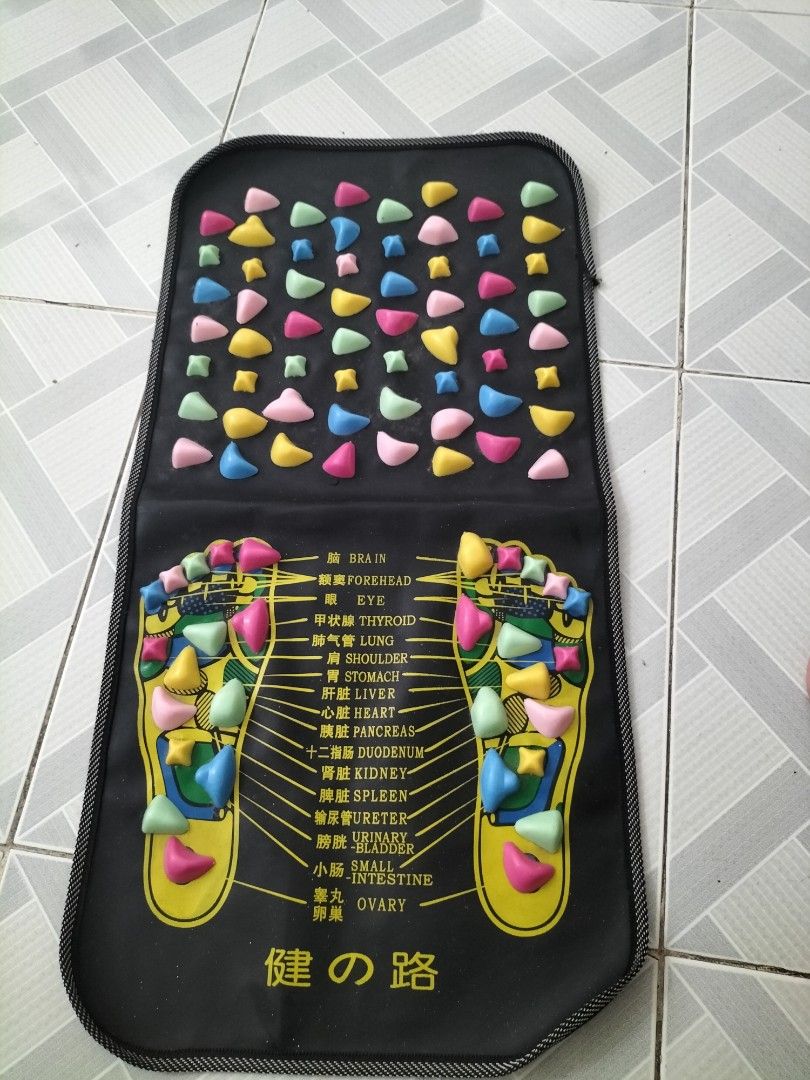 Foot Reflexology Massage Mat (Category: Massage Devices) located in Las Pinas. Submitted by declutter.with.eca (Listing ID 1433606876, Image 1). Description: - Foot massage mat with colorful reflexology nodes. - Features a black base with foot reflexology point diagram. - Foldable design for easy storage and portability. - Textured nodes on the back for added massage. - Designed to stimulate pressure points on your feet..