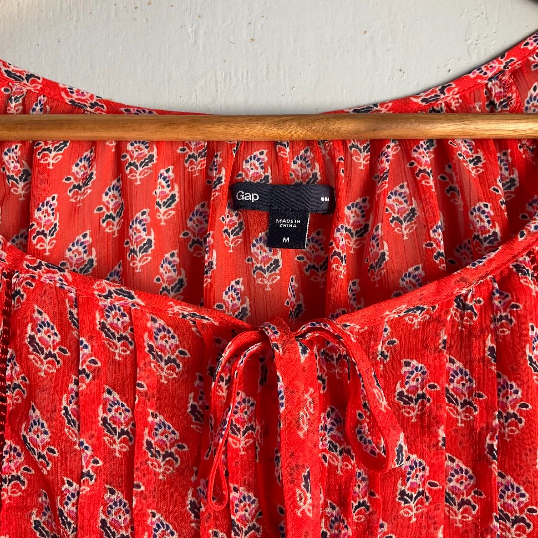 GAP | Floral Print Pleated Peasant Blouse (Category: Blouses) located in Cagayan de Oro. Submitted by random_thrift.av (Listing ID 1433639106, Image 3). Description: ◇Dim: W19 L24 ◇ Vibrant coral-red top featuring a delicate all-over floral motif ◇ Flattering pleated front detailing, a dainty tie-neckline, and comfortable elasticized puff sleeves ◇ Due to brightness, lighting or other factors, the color of the actual product can be slightly diffe