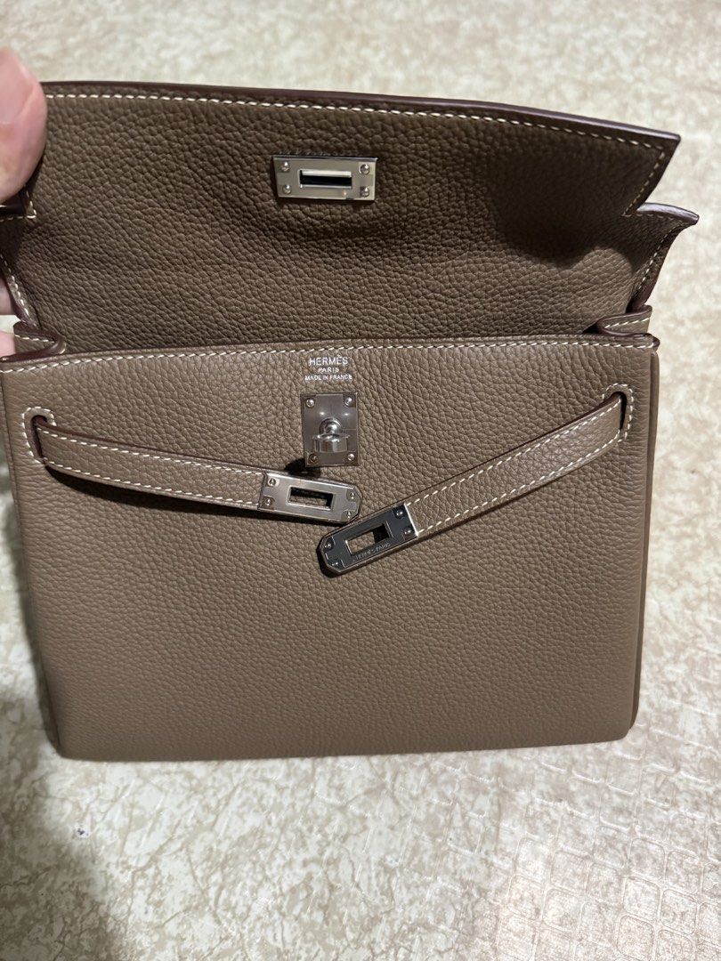 Hermes Kelly 25 Retourne (Category: Luxury Bags & Wallets) located in Lipa City. Submitted by chrs.bags (Listing ID 1433725478, Image 2). Description: Kelly 25 handbag sourced from Japan - Color: Etoupe - Features: - Top handle - Detachable shoulder strap - Flap closure with turn lock - Palladium hardware - Interior pouch - contrast white stitching details - Brand name visible on interior and strap - Condition: Slight sign of use overall good 10/