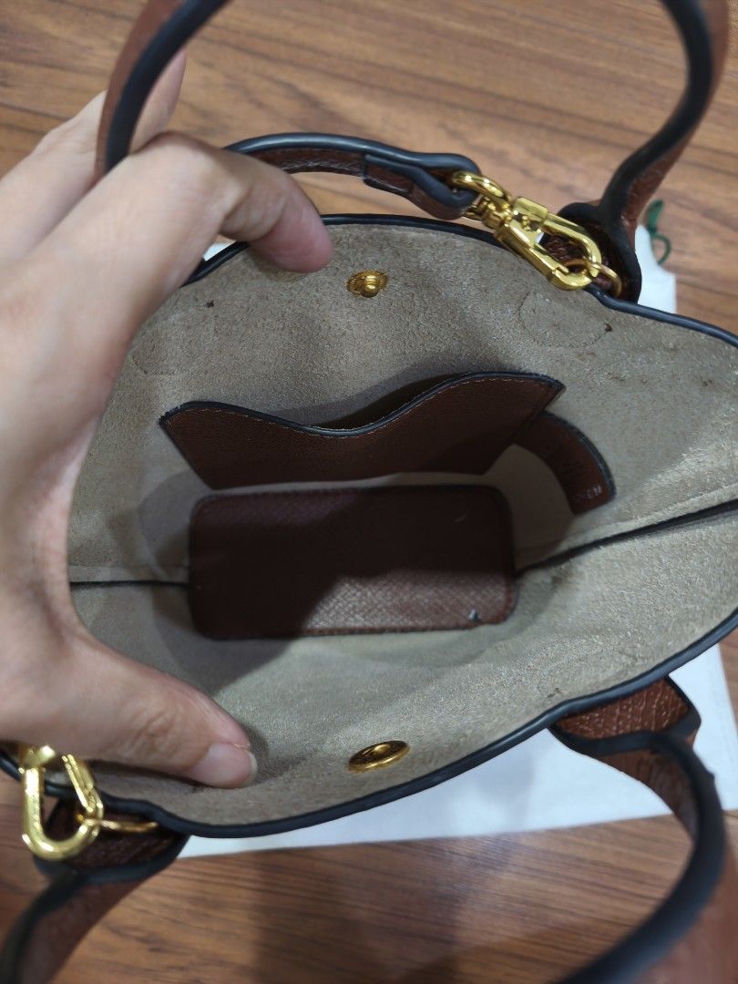 Longchamp Brown Handbag with Strap (Category: Luxury Bags & Wallets) located in Quezon City. Submitted by jhays02 (Listing ID 1433706357, Image 3). Description: - Longchamp handbag - Top handle and detachable strap - Textured exterior - Gold-tone clasp - Interior pocket - Includes dust bag.